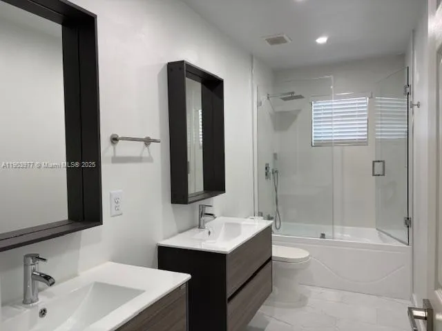 a bathroom with a sink mirror toilet and bathtub