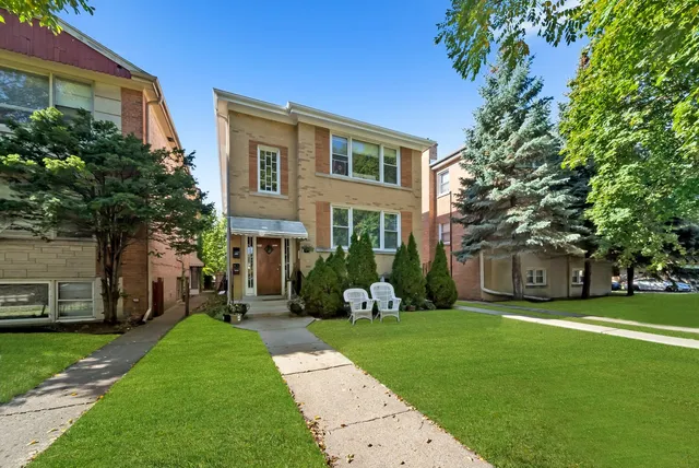 a view of a house with a big yard plants and large trees