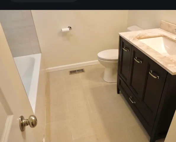 a bathroom with a granite countertop sink toilet and shower