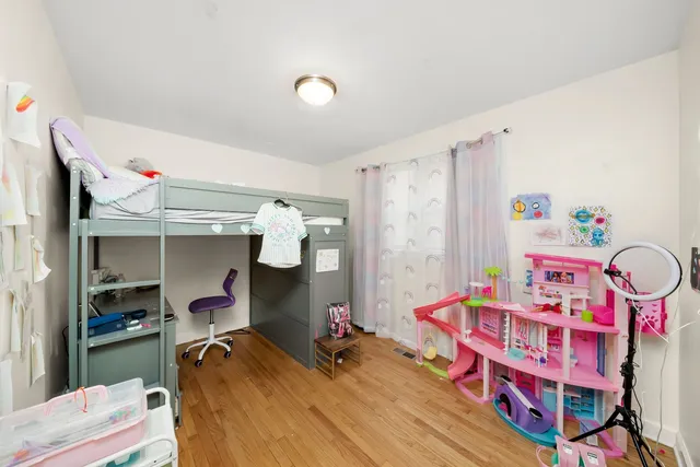 a bedroom with baby bed and a window