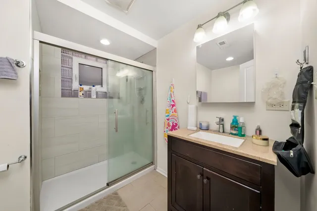 a bathroom with a sink a mirror and a shower