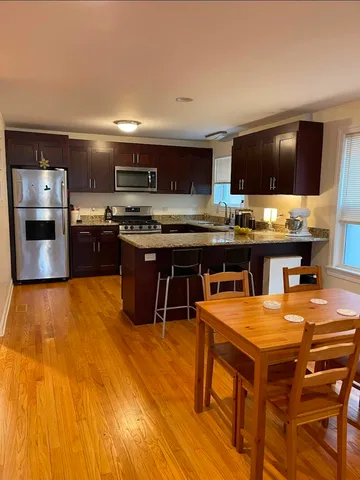 a kitchen with a wooden table and chairs