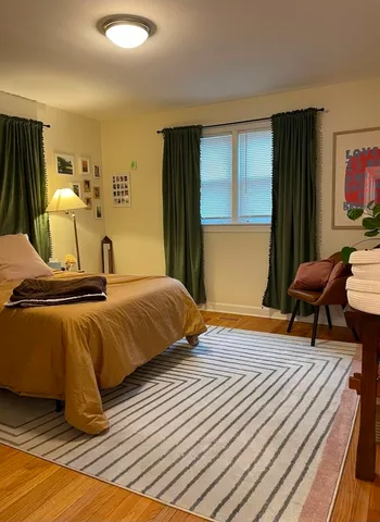 a bedroom with bed and wooden floor