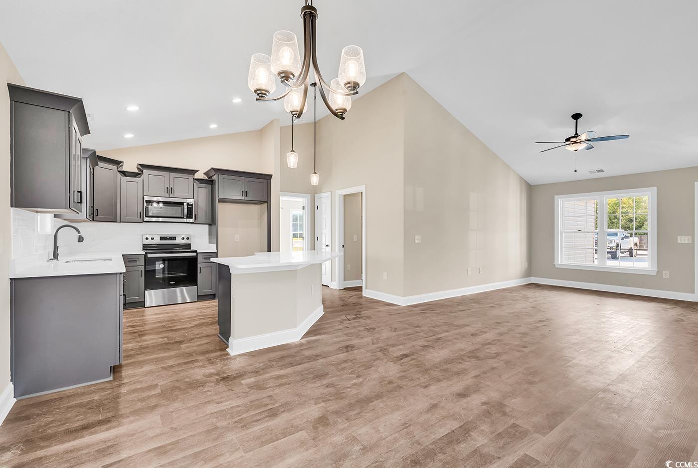 3261 Red Bluff Road Loris, SC 29569 - Photo 10 of 39 Kitchen featuring decorative light fixtures, stainless steel appliances, a center island, light wood-style floors, and high vaulted ceiling