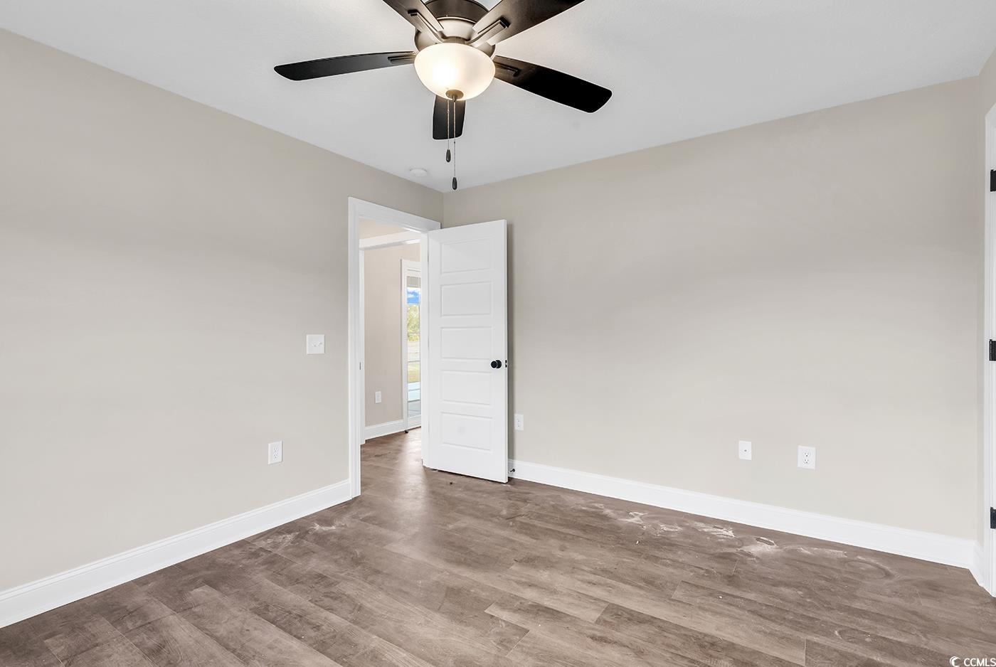 3261 Red Bluff Road Loris, SC 29569 - Photo 21 of 39 Empty room with wood finished floors and ceiling fan
