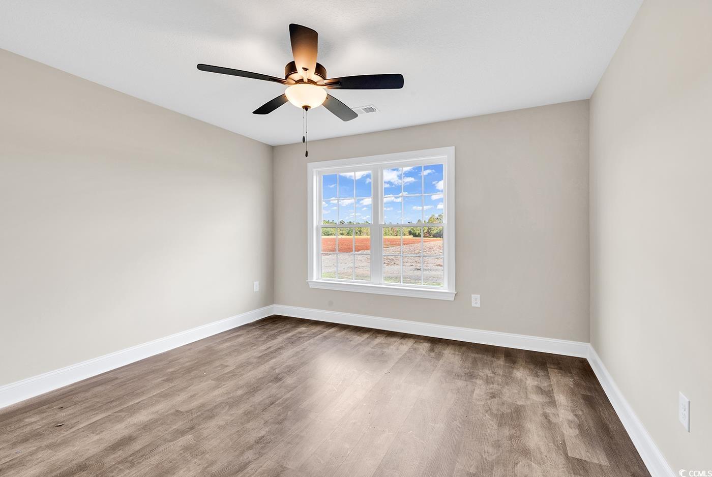 3261 Red Bluff Road Loris, SC 29569 - Photo 24 of 39 Empty room featuring wood finished floors and a ceiling fan