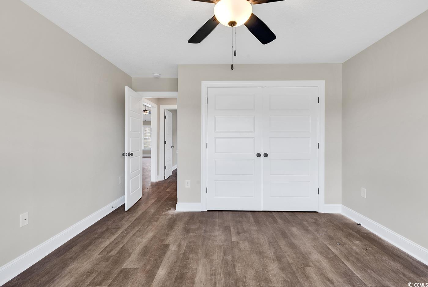 3261 Red Bluff Road Loris, SC 29569 - Photo 25 of 39 Unfurnished bedroom featuring dark wood-type flooring, a closet, and a ceiling fan