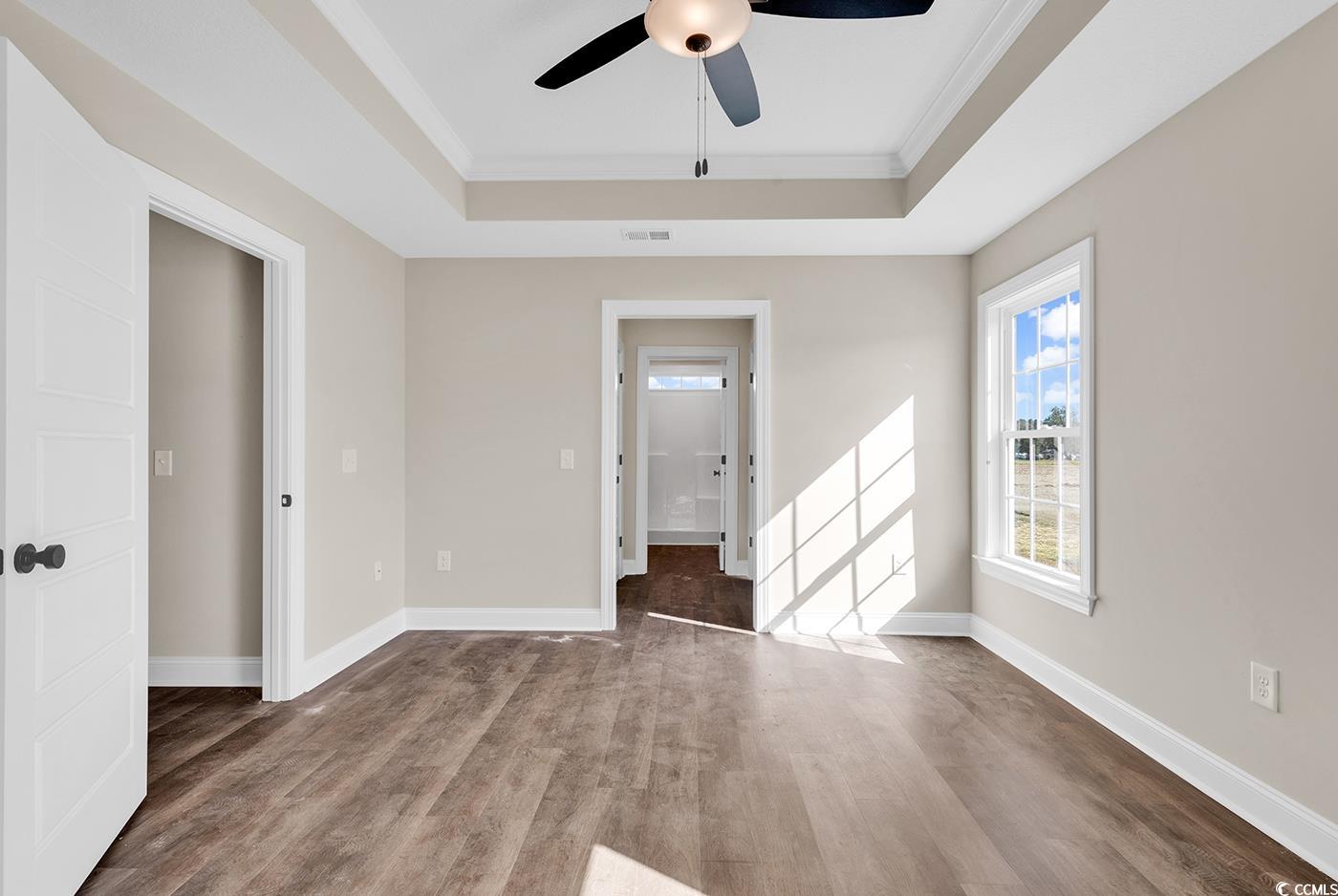 3261 Red Bluff Road Loris, SC 29569 - Photo 29 of 39 Empty room with a tray ceiling, wood finished floors, ornamental molding, and ceiling fan