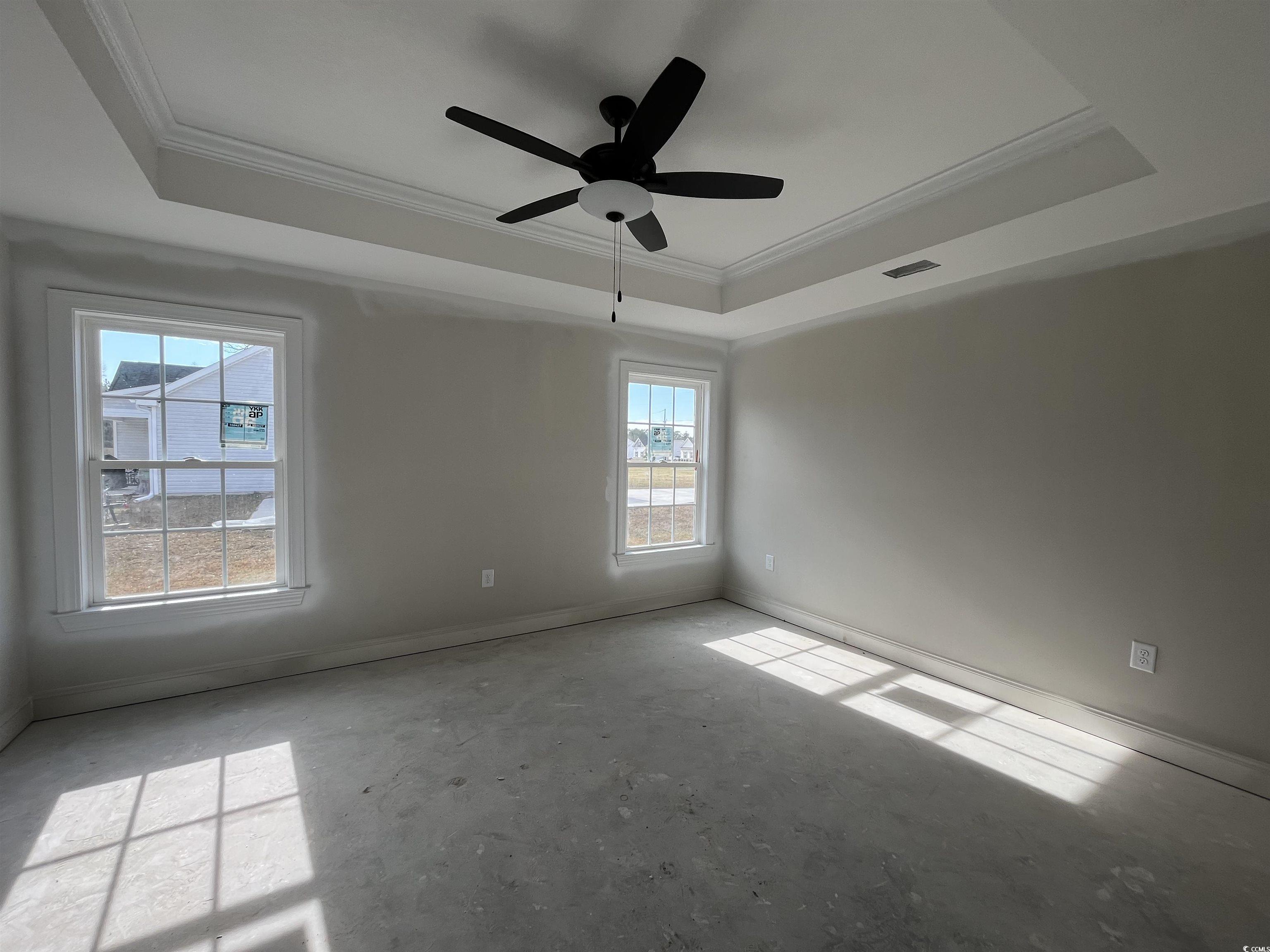 3261 Red Bluff Road Loris, SC 29569 - Photo 4 of 39 Empty room featuring crown molding, ceiling fan, a raised ceiling, and unfinished concrete floors