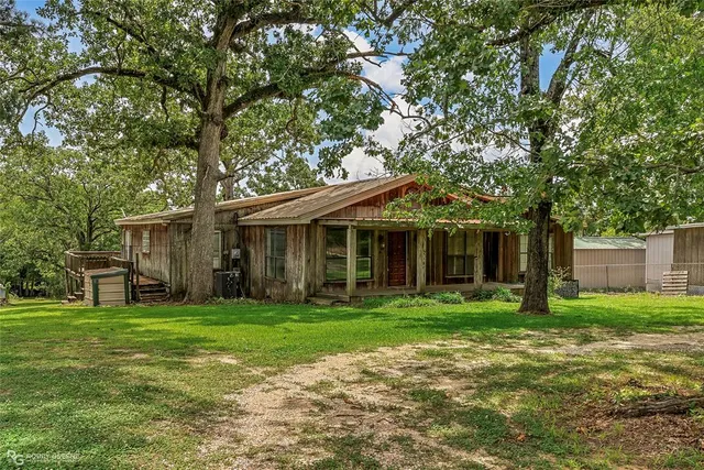 a front view of a house with a yard and trees