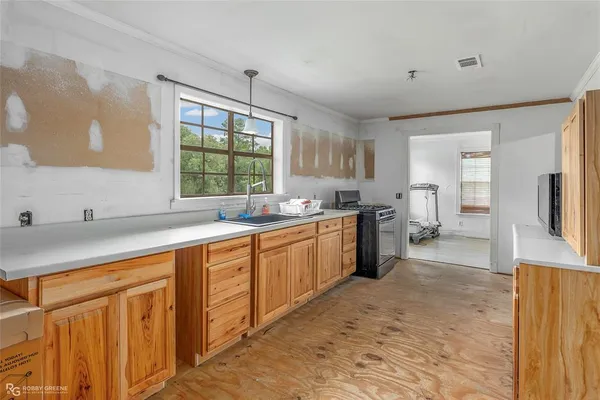 a large kitchen with kitchen island a sink a stove a refrigerator and cabinets