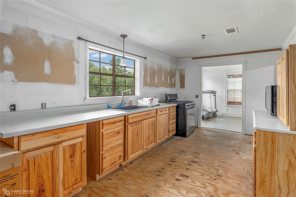 411 Camp Bistno Road Doyline, LA 71023 - Photo 21 of 32 a large kitchen with kitchen island a sink a stove a refrigerator and cabinets