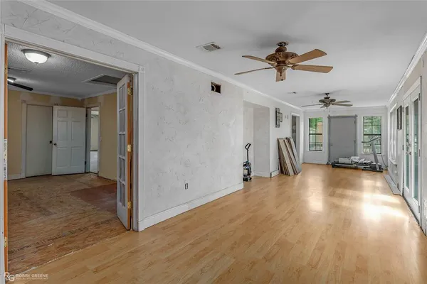 a view of empty room with wooden floor and ceiling fan