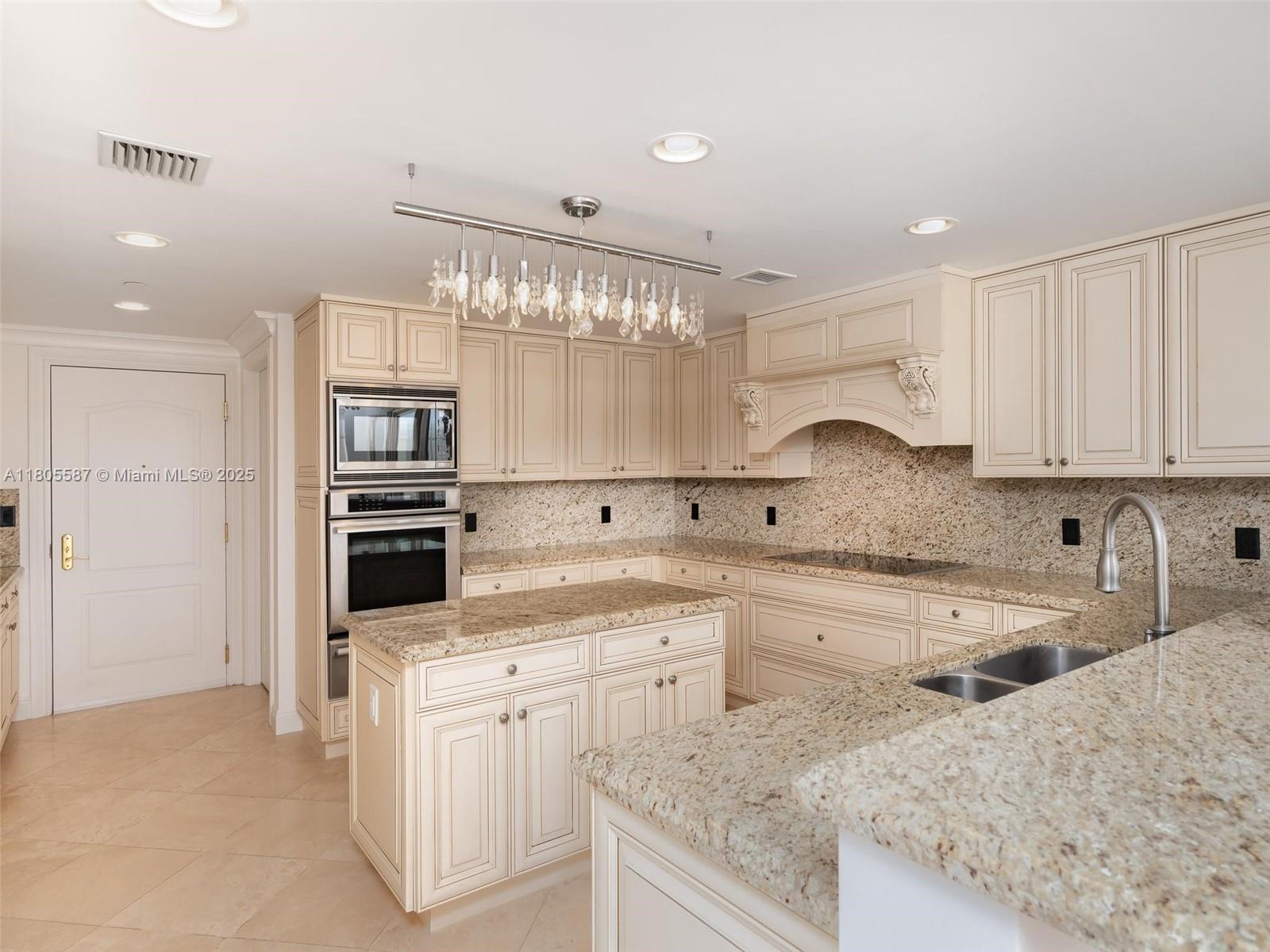 200 East Palmetto Park Road, Unit 700 Boca Raton, FL 33432 - Photo 7 of 36 a kitchen with granite countertop a sink stainless steel appliances and white cabinets