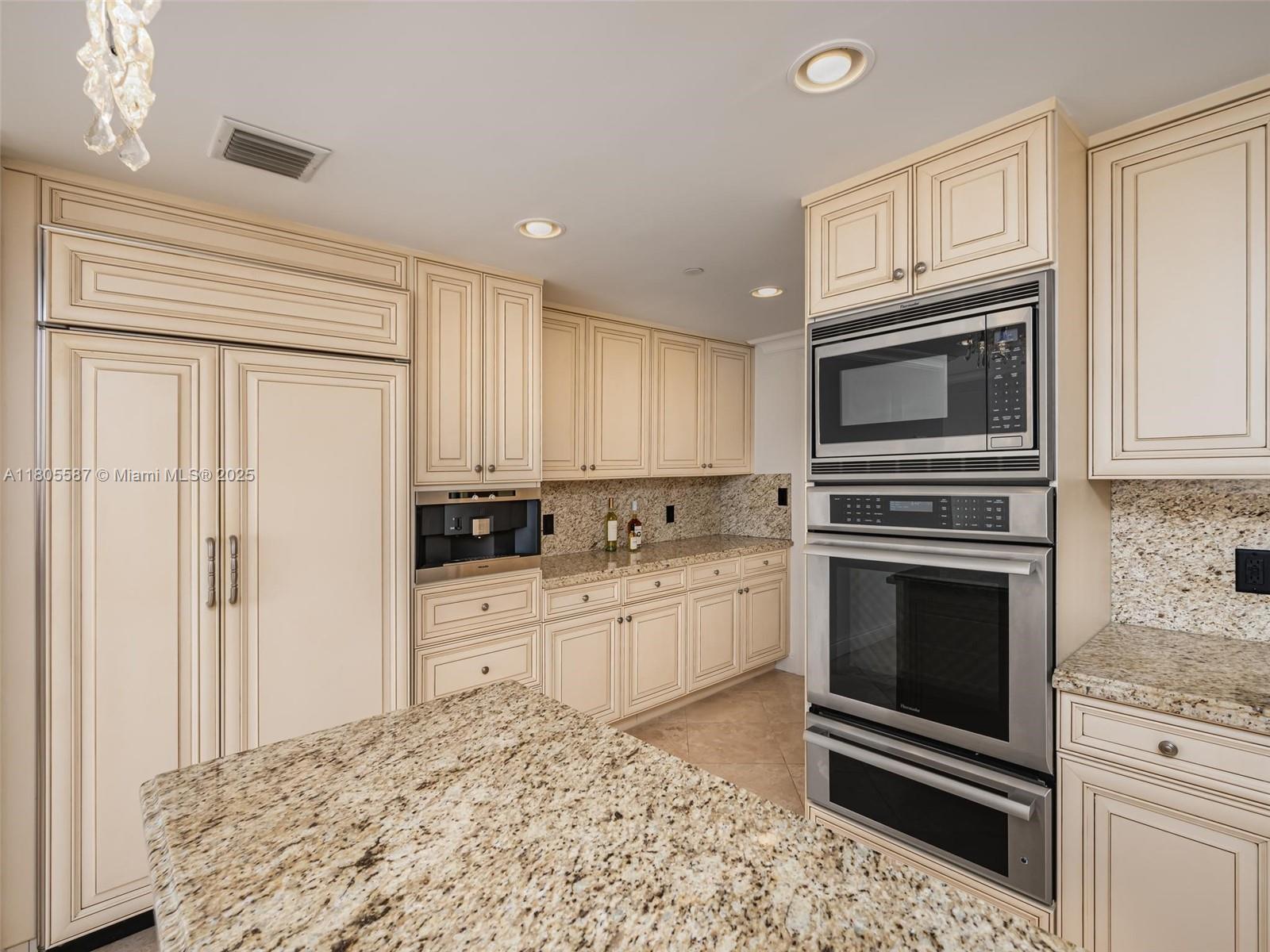 200 East Palmetto Park Road, Unit 700 Boca Raton, FL 33432 - Photo 8 of 36 a kitchen with granite countertop a refrigerator stove and microwave