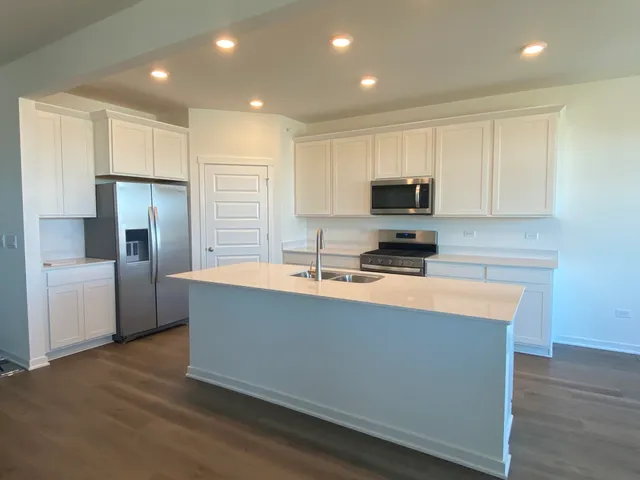 a kitchen with stainless steel appliances granite countertop a stove a sink and a refrigerator