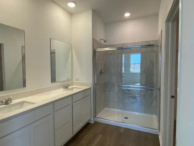 a bathroom with a shower sink and mirror