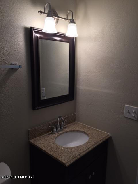 3853 Bess Road Jacksonville, FL 32277 - Photo 20 of 22 a bathroom with a granite countertop sink a mirror and vanity