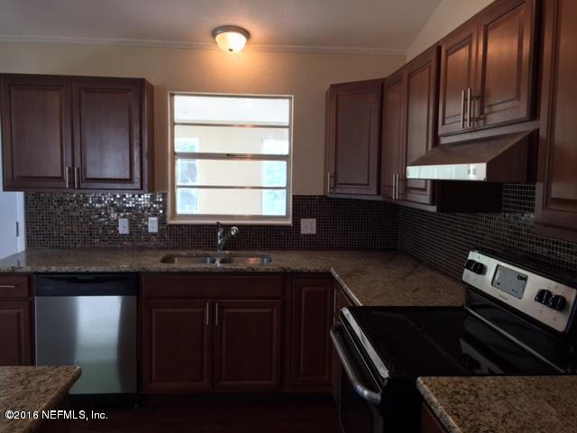 3853 Bess Road Jacksonville, FL 32277 - Photo 4 of 22 a kitchen with granite countertop stainless steel appliances a sink stove and cabinets