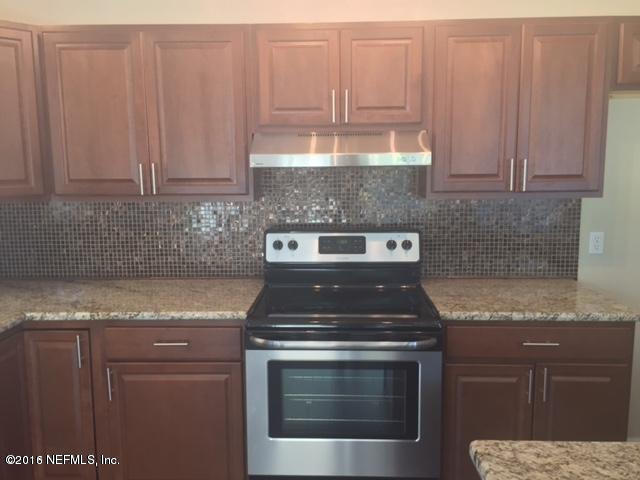 3853 Bess Road Jacksonville, FL 32277 - Photo 5 of 22 a kitchen with granite countertop a stove sink and cabinets