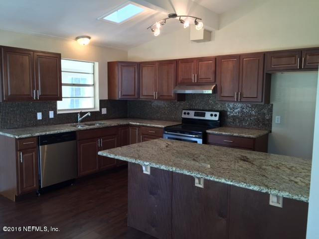 3853 Bess Road Jacksonville, FL 32277 - Photo 6 of 22 a kitchen with stainless steel appliances granite countertop a sink a stove a refrigerator cabinets and wooden floor