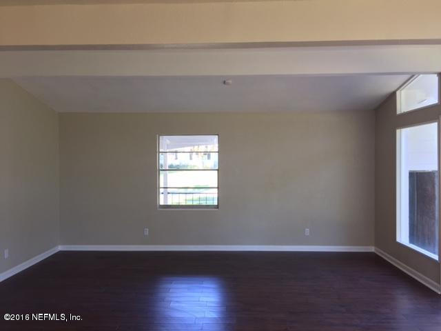 3853 Bess Road Jacksonville, FL 32277 - Photo 10 of 22 a view of an empty room with wooden floor and a window