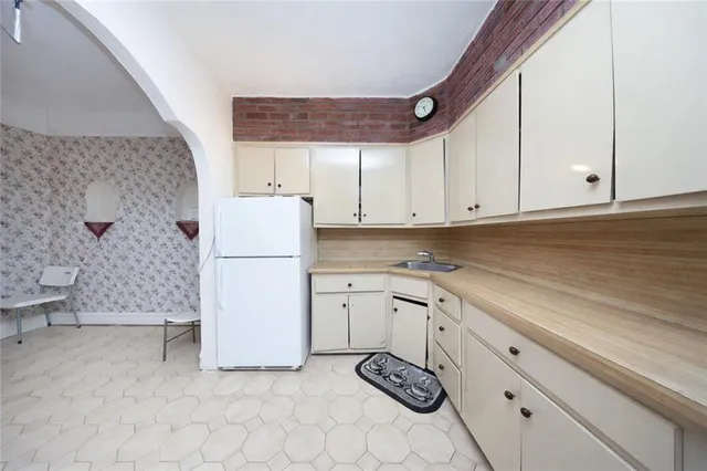 a kitchen with granite countertop a stove a sink dishwasher and a refrigerator