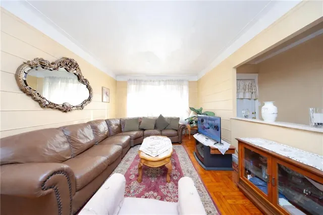 a dining room with wooden floor a chandelier a wooden table and chairs
