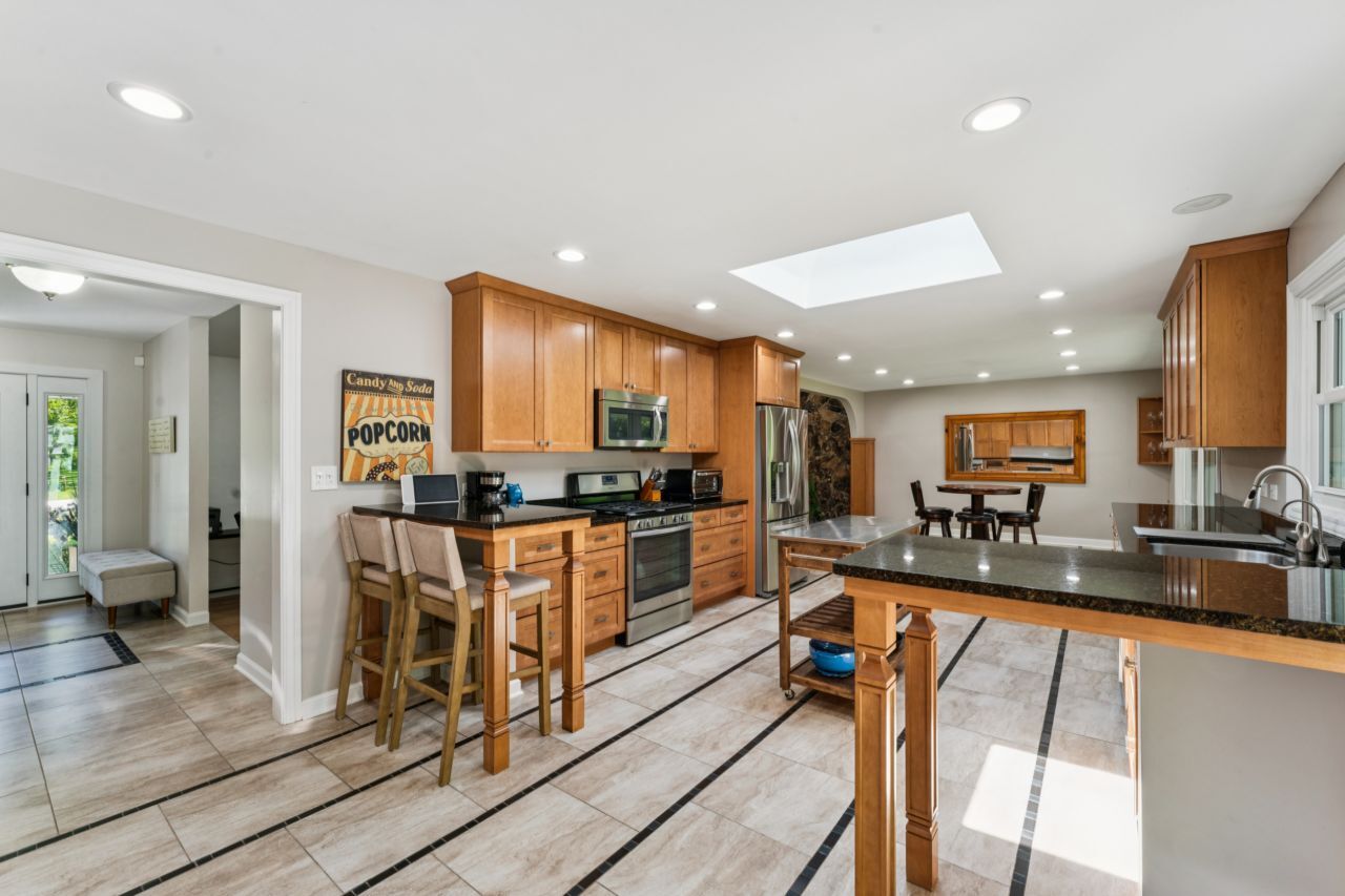 328 Windsor Lane Inverness, IL 60010 - Photo 8 of 33 a kitchen with stainless steel appliances kitchen island granite countertop a refrigerator a stove a sink dishwasher and white cabinets with wooden floor