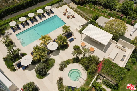 a view of a swimming pool with a patio and a fountain