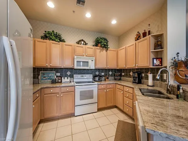 a kitchen with a sink appliances cabinets and furniture