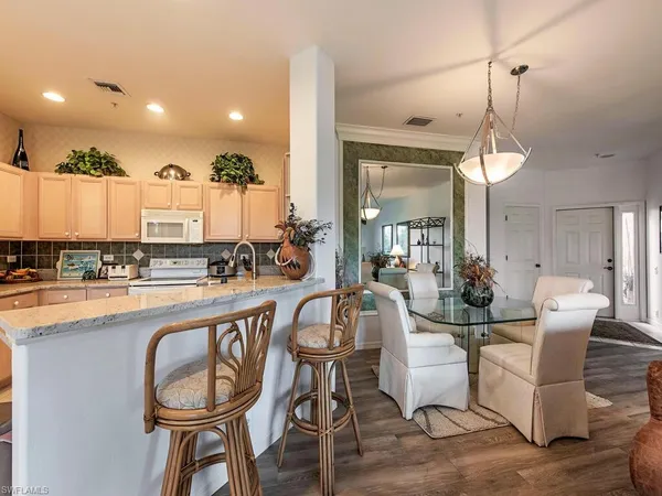 a very nice looking dining room with kitchen island furniture a chandelier