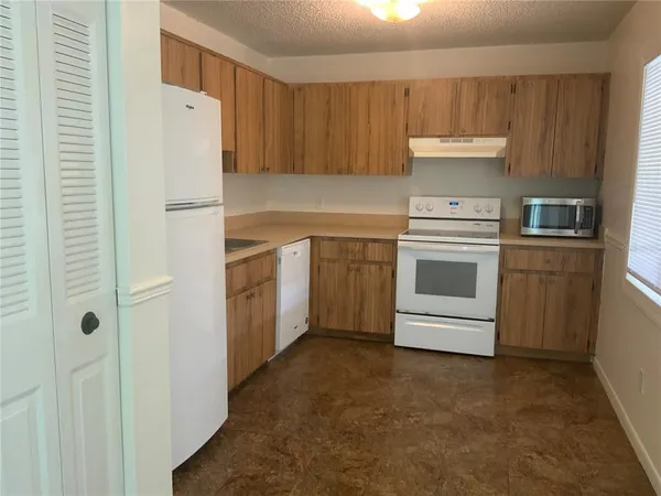 a kitchen with stainless steel appliances granite countertop a refrigerator a sink and a stove