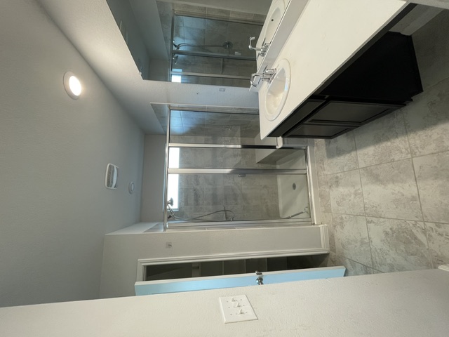 12401 Amber Lynn Path Manor, TX 78653 - Photo 15 of 33 A well-lit bathroom features a double vanity and a glass-enclosed shower, creating a fresh, functional space.
