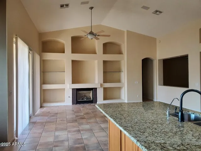 a kitchen with kitchen island a counter top space a sink stainless steel appliances and cabinets