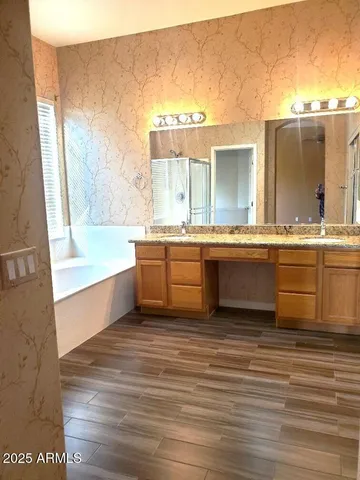 a large kitchen with granite countertop a sink and a white cabinets