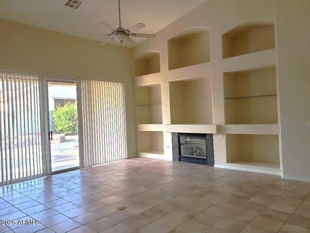 an empty room with windows and a fireplace