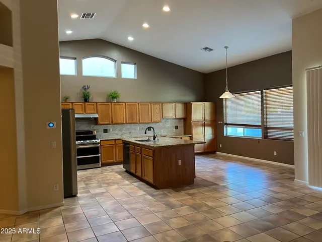 a large kitchen with stainless steel appliances a large counter top