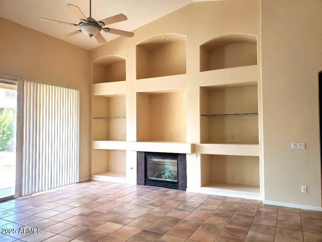 a view of an empty room with a fireplace and a window