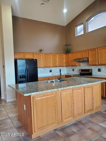 a kitchen with stainless steel appliances granite countertop a sink and a stove