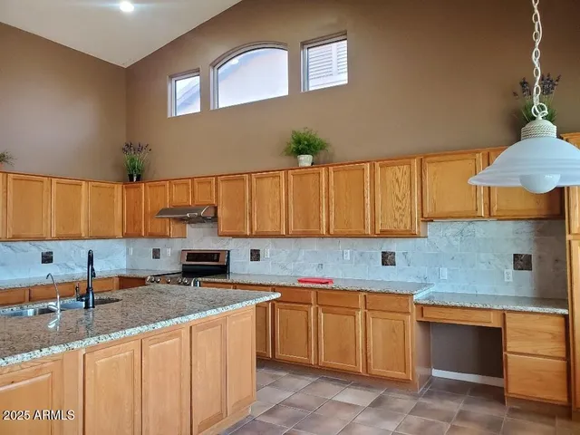 a kitchen with a sink a stove and cabinets