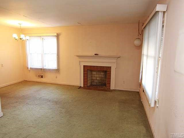 1006 Gregg Street Raleigh, NC 27601 - Photo 3 of 12 an empty room with windows and fireplace