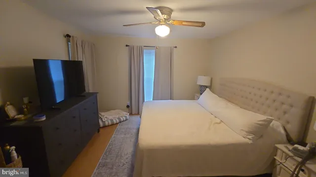 a bedroom with a bed and a flat tv screen on the dresser