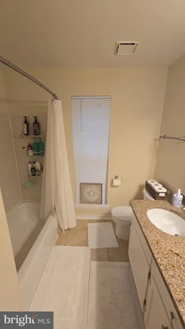 a bathroom with a granite countertop sink a mirror and a shower
