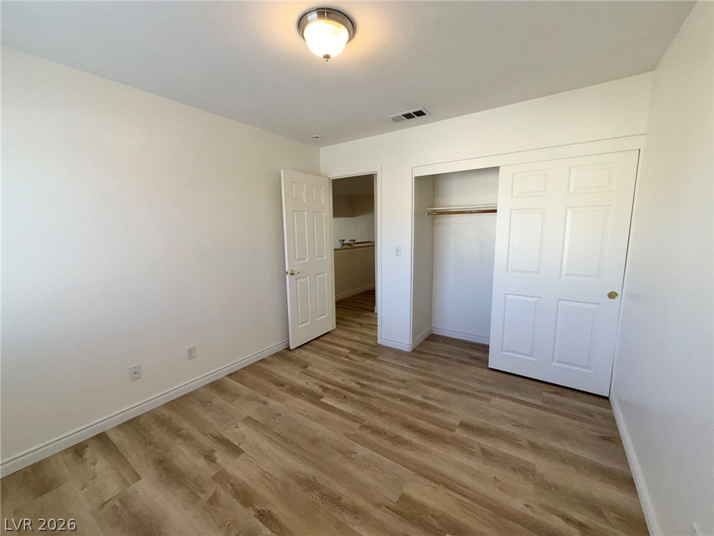 9729 Trail Rider Drive Las Vegas, NV 89117 - Photo 21 of 26 Natural wood-look flooring and ample closet space define this serene bedroom sanctuary.