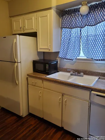 a kitchen with a sink and a refrigerator