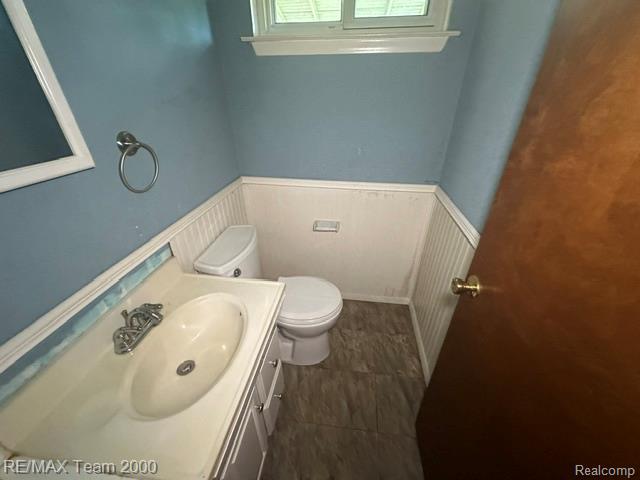 30600 Fort Road Rockwood, MI 48173 - Photo 17 of 28 Bathroom featuring a vanity with an integrated sink, polished chrome faucet, white beadboard wainscoting, and tiled flooring
