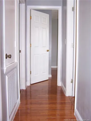 a view of an empty room with wooden floor