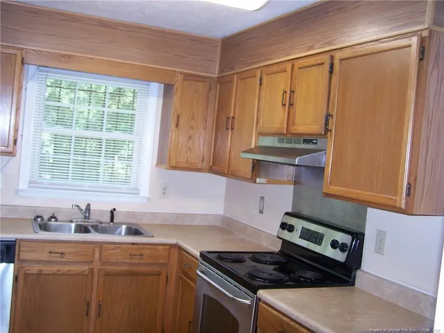 a kitchen with stainless steel appliances granite countertop a sink stove and cabinets