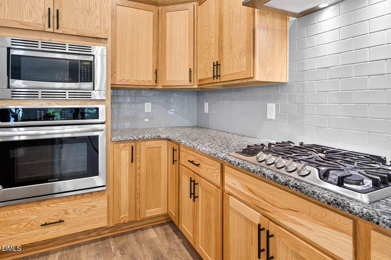 248 Kavanaugh Road Wake Forest, NC 27587 - Photo 6 of 54 Gas Cooktop, vent hood and tile backsplash